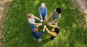 A group of five people joining hands in a circle, seen from above. - Google Nano Banana 2