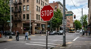A red stop sign on a street corner displaying the word 