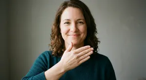 Photorealistic close-up portrait of a person clearly performing the American Sign Language gesture for 
