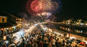 A nighttime festival with fireworks in the sky, food stalls lined up, and crowds mingling. - Google Nano Banana Pro