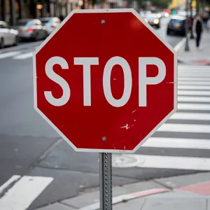 A red stop sign on a street corner displaying the word 