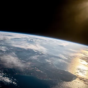 Photorealistic aerial photograph clearly showing the edge of the Earth from space, capturing realistic curvature, atmosphere, and sunlight reflections - Black Forest Labs Flux 2 Pro
