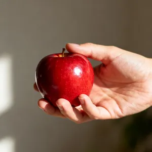 A realistic photo of a hand holding a red apple, with all fingers clearly visible. - Bytedance Seedream 4.0