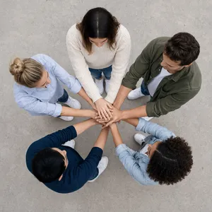 A group of five people joining hands in a circle, seen from above. - Reve Reve 2.1