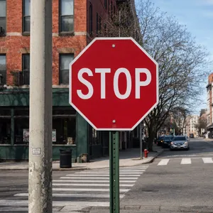 A red stop sign on a street corner displaying the word 