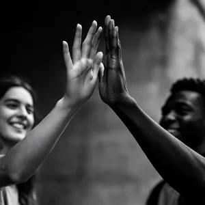Two people high-fiving, with focus on their hands meeting mid-air. - Krea Krea 2 Large