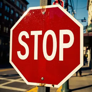 A red stop sign on a street corner displaying the word 