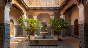 A traditional Moroccan riad courtyard with detailed zellige tilework, flowing fountain, citrus trees, and ornate woodwork. Morning light casting intricate shadow patterns. - XAI Grok Imagine